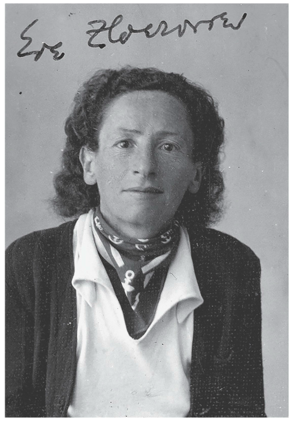 Eve Adams is an afab butch person wearing a loose blue cardigan, white button-down, and ascot with anchors on it. She had medium length curly/wavy hair.